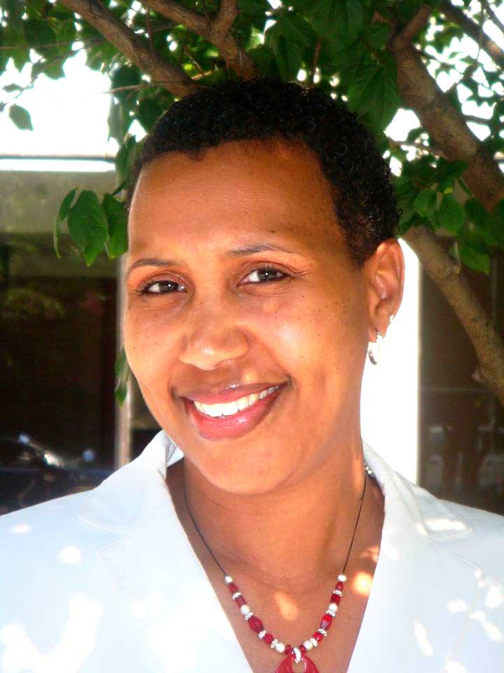 Woman in a white suit smiling broadly