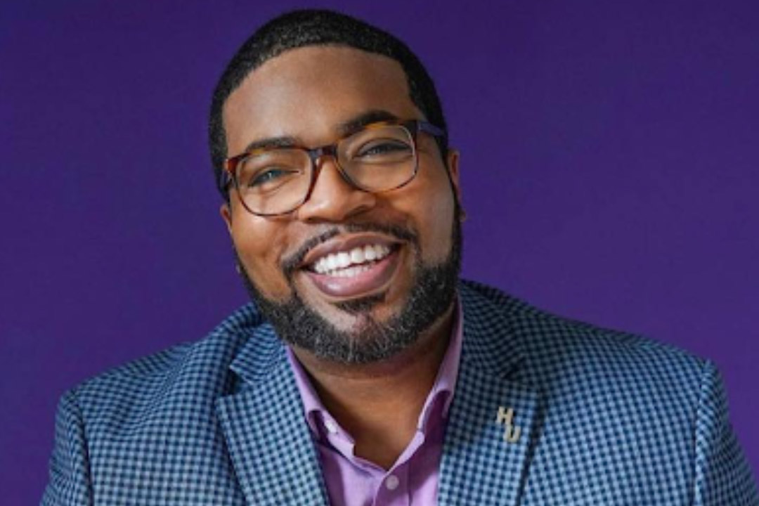 Man in checkered suit with purple shirt 