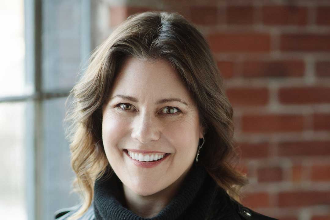 woman with a broad smile wearing a leather jacket