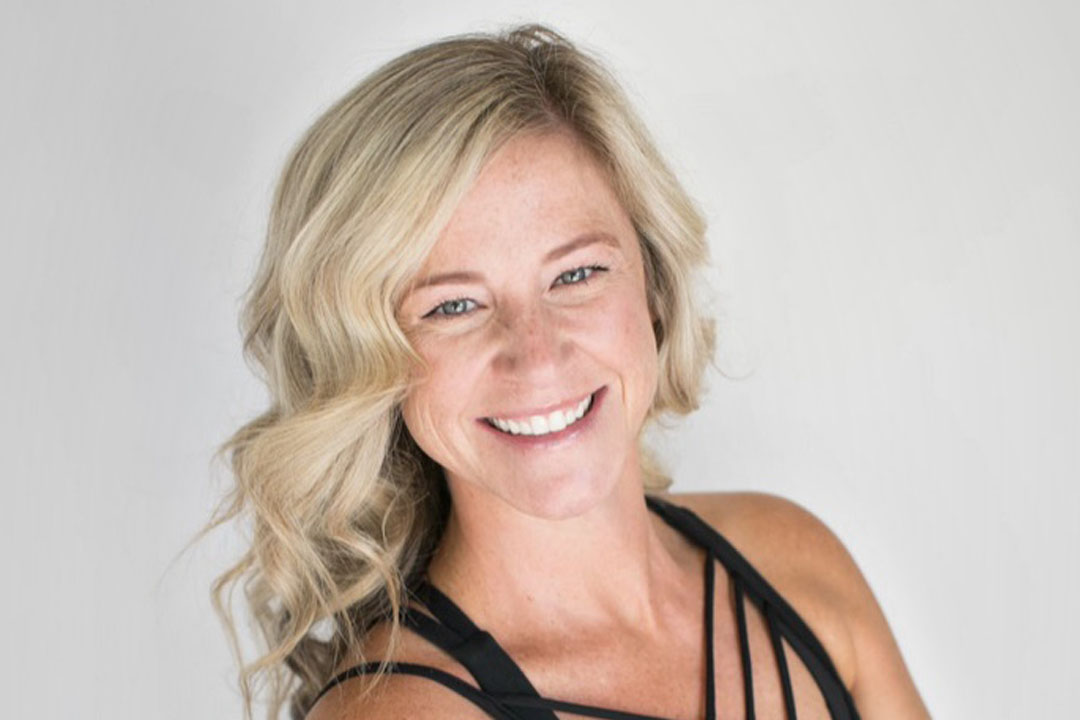Headshot of a woman with shoulder length blonde hair smiling broadly