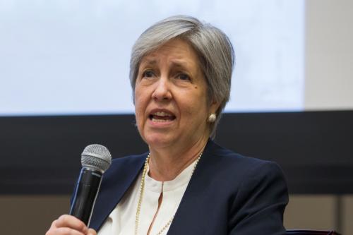 Woman in a blazer with microphone 