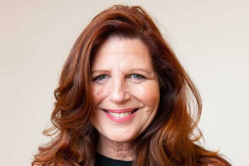 Woman smiling broadly wearing a dark shirt