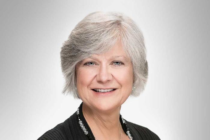 Woman with a dark jacket smiling broadly